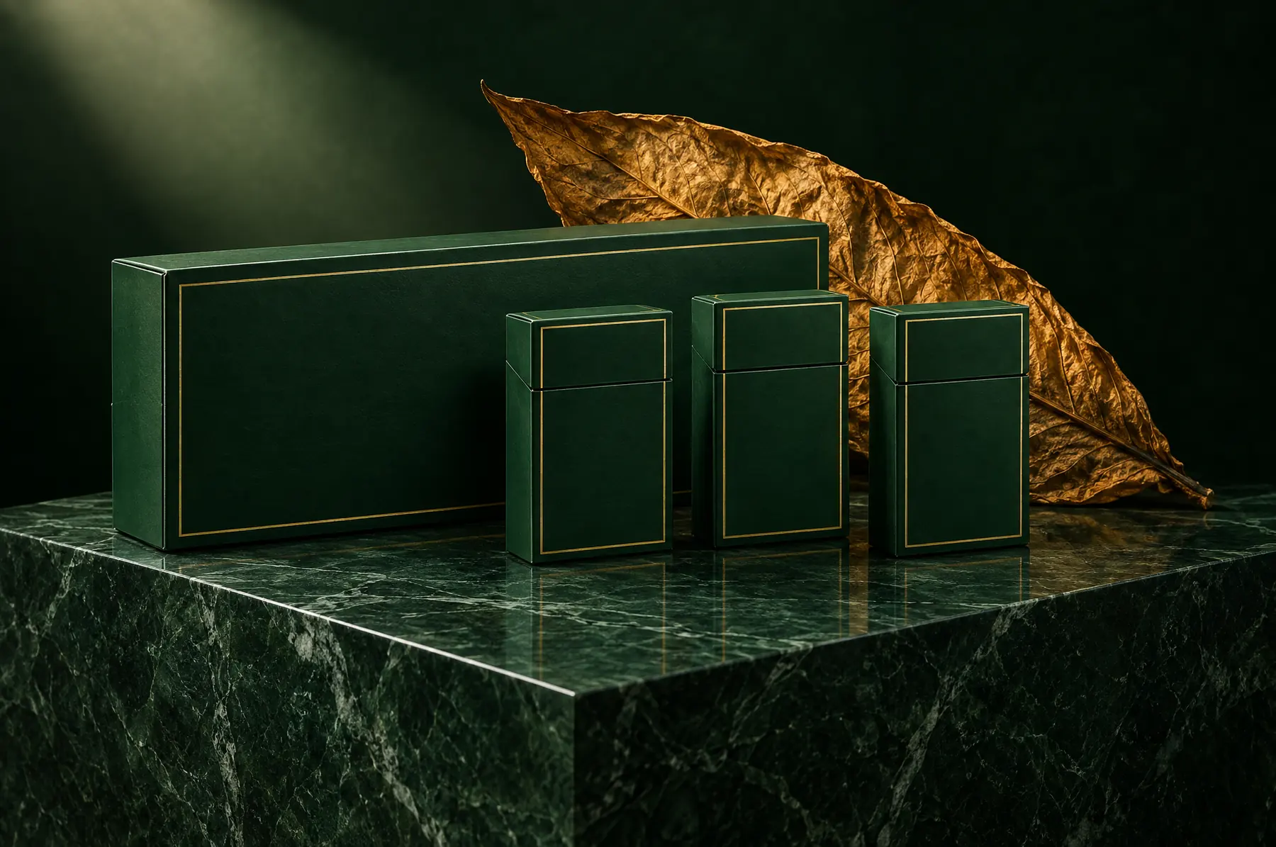 Cigarette carton and packs on green marble beside a cured tobacco leaf